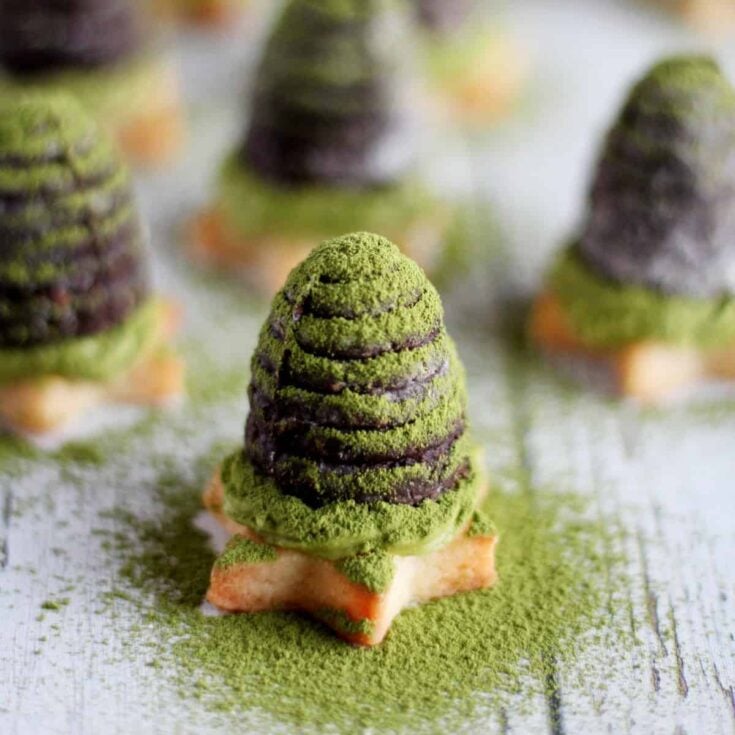 Four pieces of matcha chocolate beehives dusted with more matcha green tea powder on a wooden counter top.